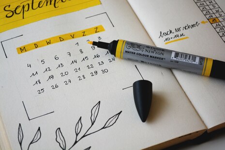 Ein Papierkalender ist zu sehen mit einem Markerstift in gelb.