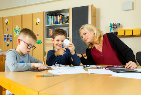 Kinder der 1. Klassen basteln mit Erzieherin